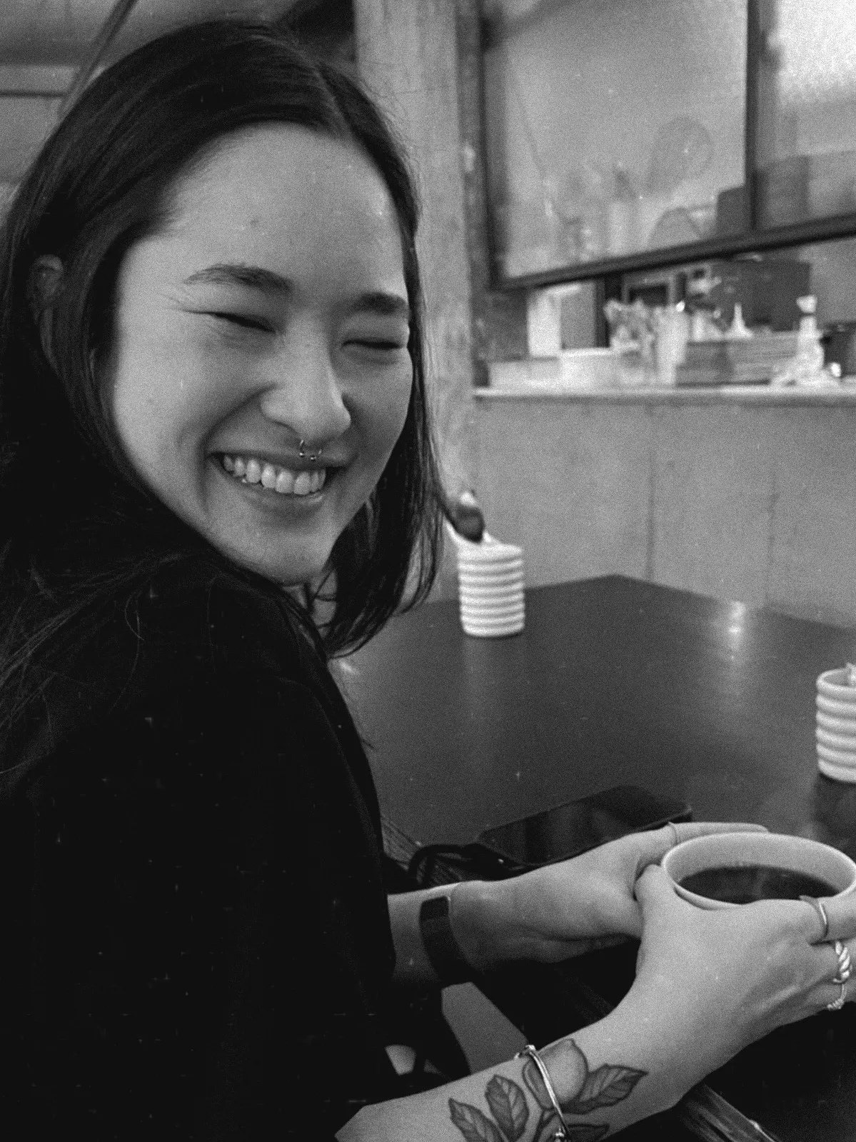 Larissa smiling, holding a cup of coffee